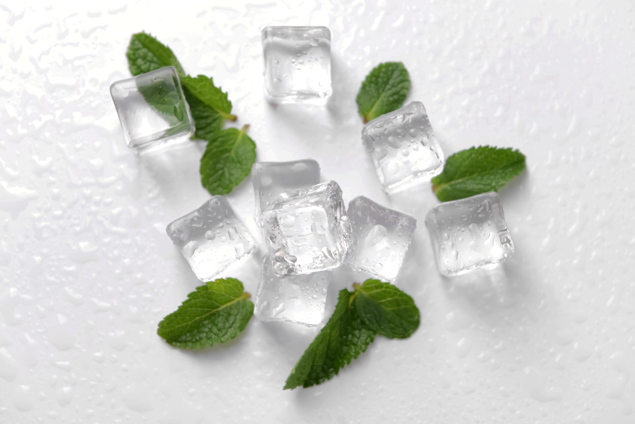 Ice cubes and mint leaves on white background